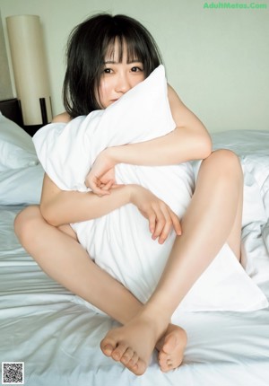 A woman in a black and white striped bikini posing on a bed.