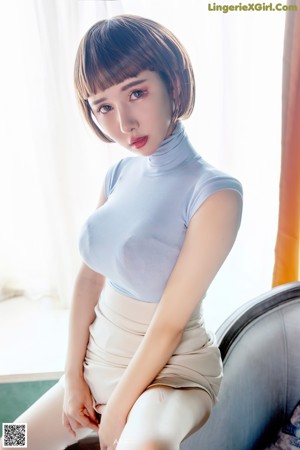 A woman in a blue shirt and pink panties is bending over.